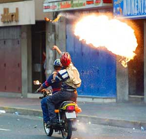 man on a motorcycle throwing a Molotov cocktail