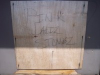 wooden board defaced with 'PINK LAdIZ STONEZ'