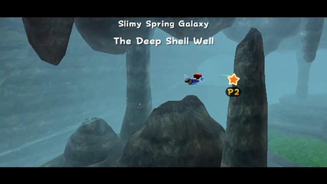 Mario flying through a dank cave, foggy with rocks and a small bit of vegetation.